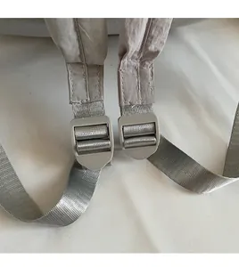 Detail of adjustable gray nylon shoulder strap with smooth plastic buckle on backpack