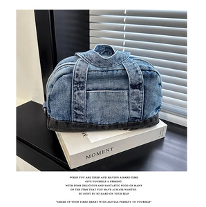 Close-up of retro washed denim handbag with durable bottom stitching on white books