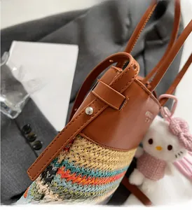 Dettaglio tracolla in pelle e borsa a secchiello intrecciata con borchie in metallo