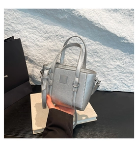 Dettaglio della mini borsa tote metallizzata argento con finitura testurizzata e tracolla