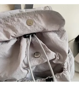 Detailed macro view of gray nylon backpack fabric and shiny metal magnetic buckle closure