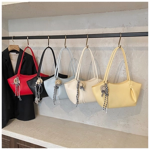 Detail of multi-color tote bags in red black blue cream and yellow with straw hat charms