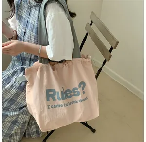 Detail der gerafften Kante mit Schriftzug auf pinkfarbenem Shopper mit grauen Riemen