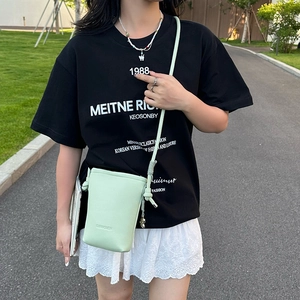 Détail du mini sac bandoulière vert menthe avec logo embossé et ornements argentés