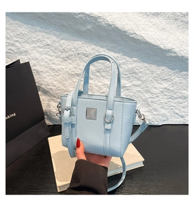 Dettaglio mini borsa tote in pelle azzurra a grana incrociata con placca metallica