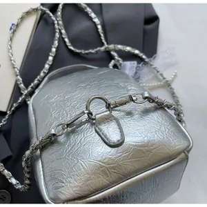 Close-up of silver crinkled leather bag featuring durable metal hook and chain strap