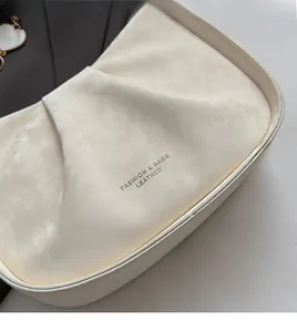 Gros plan sur le daim beige plissé avec lettrage doré Fashion & Bags Leather