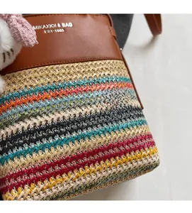 Dettaglio della trama intrecciata multicolore con finiture in pelle e ciondolo