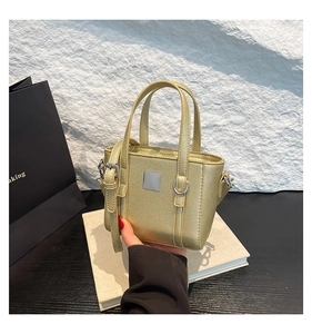 Dettaglio della borsa a secchiello champagne oro con texture metallica e pelle sintetica