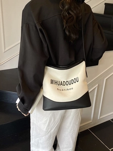 Minimalist black and white canvas bucket bag with leather strap for women
