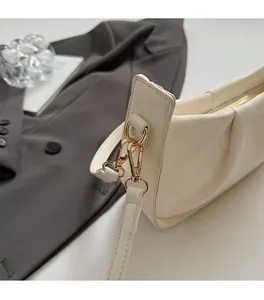 Gros plan détaillé du sac bandoulière blanc crème avec ferrures dorées de haute qualité
