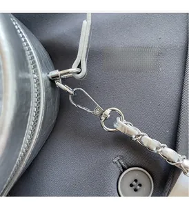 Detail of silver metallic lace backpack featuring high-shine hardware and chain strap