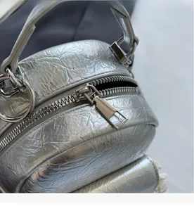 Close-up of smooth metal zipper and silver wrinkled texture on a fashion backpack
