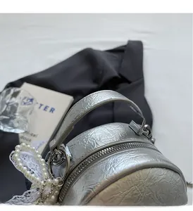 Silver bucket bag with wrinkled texture, pearl lace pendant and sturdy handle detail