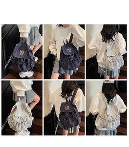 Detail view of nylon drawstring backpacks in blue and grey with Muting branding