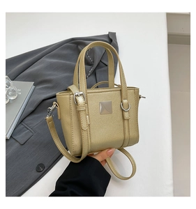 Dettaglio macro della borsa in pelle martellata oro champagne con anelli in metallo lucido