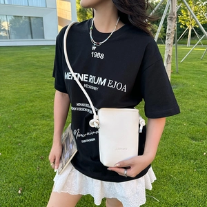 Détail du sac à téléphone blanc texture litchi avec logo SUNWOMEN et bandoulière nouée