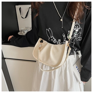 Détail du sac seau plissé blanc crème avec accessoire de breloque en forme de cœur