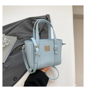 Dettaglio della mini borsa tote azzurra in pelle Saffiano con fibbia argento e manici