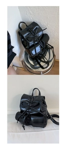Detail view of black glossy backpack with ribbon bow design and dual exterior pockets