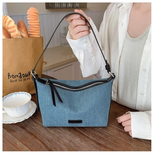 Texture dettagliata della borsa hobo in denim blu con dettagli argento e tracolla
