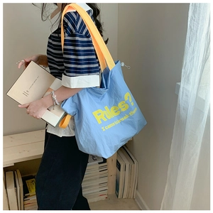Detail der blauen Canvas-Tasche mit gelbem Rules-Slogan und Lifestyle-Modell-Präsentation