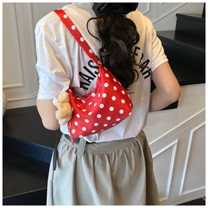 Rote Schultertasche mit weißen Punkten und einem niedlichen Plüschbären am Reißverschluss