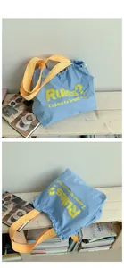 Detail der blauen Canvas-Tasche mit gelben Trägern und Rules I came to break them Slogan