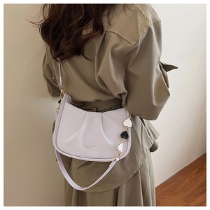 Détail du sac seau plissé lavande avec chaîne à pendentif cœur et texture en cuir PU