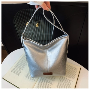 Detailed close-up of metallic silver bucket bag with logo leather patch and soft texture