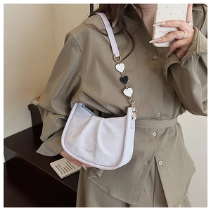 Détail du sac seau plissé blanc avec breloques en cœur et bandoulière en métal
