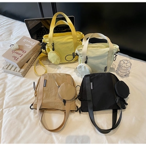 Flat lay of small nylon crossbody bags in four colors with matching mini coin pouches