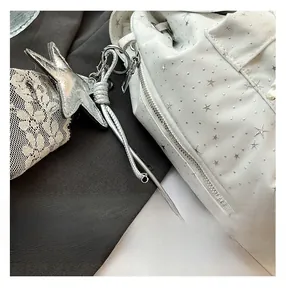 Close-up of a white backpack with silver star patterns and premium metal zipper detail