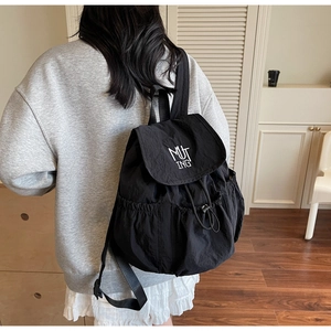 Detail eines schwarzen Nylon-Rucksacks mit MUTING-Logo-Stickerei und Kordelzug
