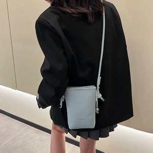Gros plan du mini sac bandoulière en cuir bleu clair avec logo SUNWOMEN et bandoulière à nœud