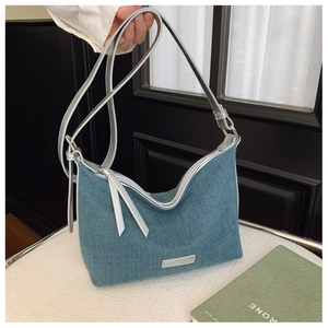 Dettaglio della borsa hobo in denim blu con tracolla regolabile e logo argento