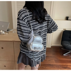 Détail du mini sac à dos argenté métallisé avec dentelle blanche et chaînettes