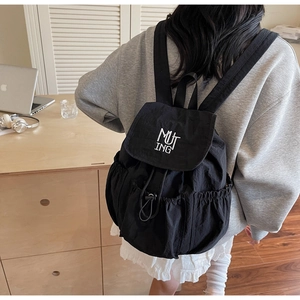 Detail of black nylon backpack with MUT ING embroidery and drawstring closure system