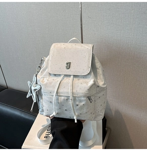 Dettaglio dello zaino in nylon bianco con stampa a stelle argento e ciondolo in metallo