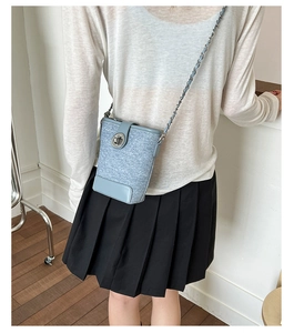 Detail of mini light blue bucket bag with silver twist lock and woven fabric texture
