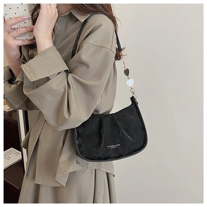 Détail du sac à bandoulière plissé noir en cuir mat avec pendentif en cœur