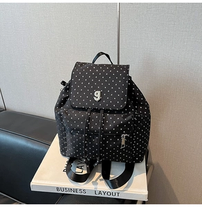 Dettaglio dello zaino in nylon nero con stampa di stelle bianche e logo G argentato