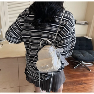 Détail du mini sac à dos crème avec cuir texturé, bordure en dentelle et perles chic