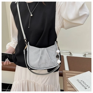 Détail du sac seau gris plissé avec bandoulière en chaîne et pendentif coeur