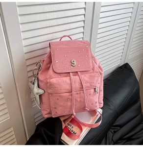 Dettaglio zaino in nylon rosa con stelle argentate e portachiavi a stella decorativo