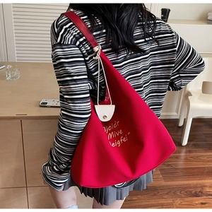 Vue détaillée d'un sac cabas rouge en toile avec broderie blanche et style épuré