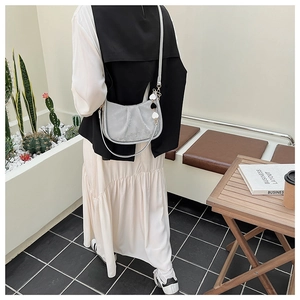 Détail du sac seau plissé argenté avec breloque coeur et bandoulière en cuir