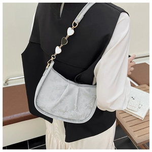 Détail du sac seau plissé gris clair avec bandoulière à chaîne en forme de cœur bicolore