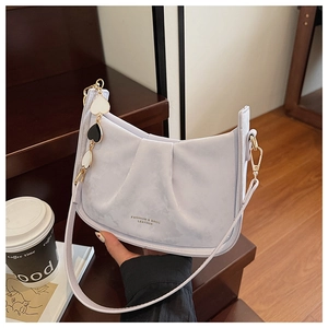 Détail du sac seau plissé lilas avec lettrage doré et pendentif en forme de coeur