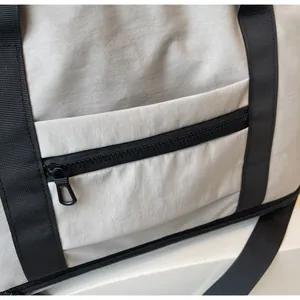 Detail of smooth black zipper and matte nylon fabric on beige travel bag
